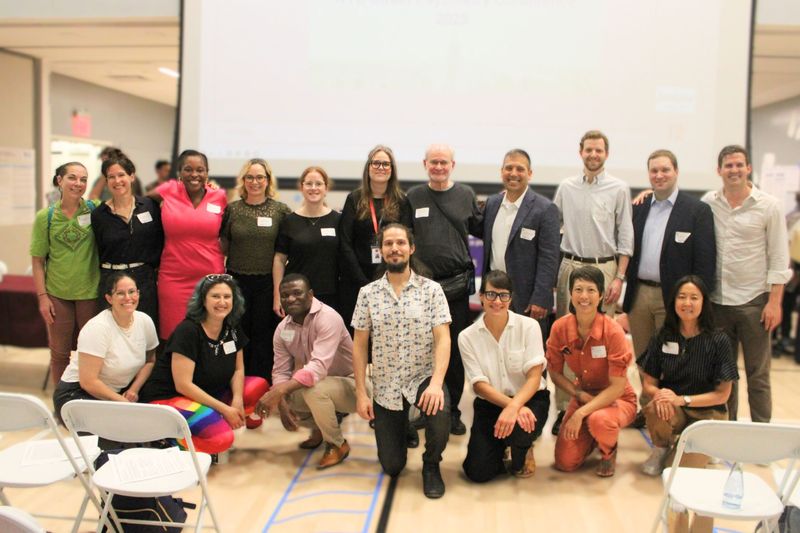 Faculty and organizers of the 2025 Street Psychiatry Conference posing together in a conference hall.